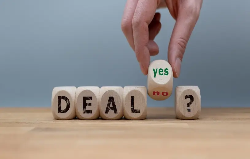 A person picking up a dice that says yes